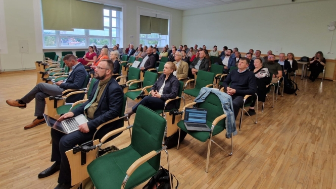 Atklāšanas pasākuma dalībnieki sēž zālē