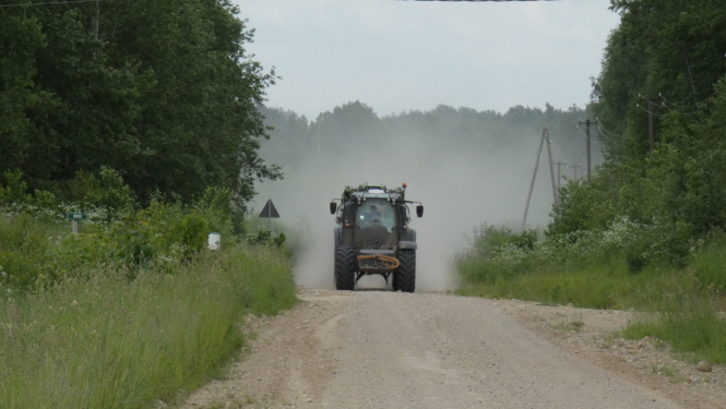 Braucošs traktors uz ceļa