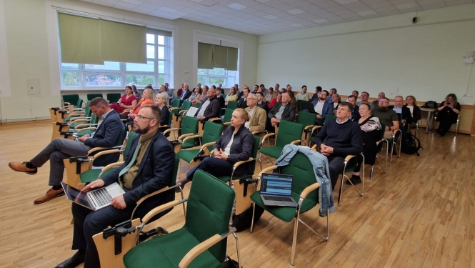 Atklāšanas pasākuma dalībnieki sēž zālē