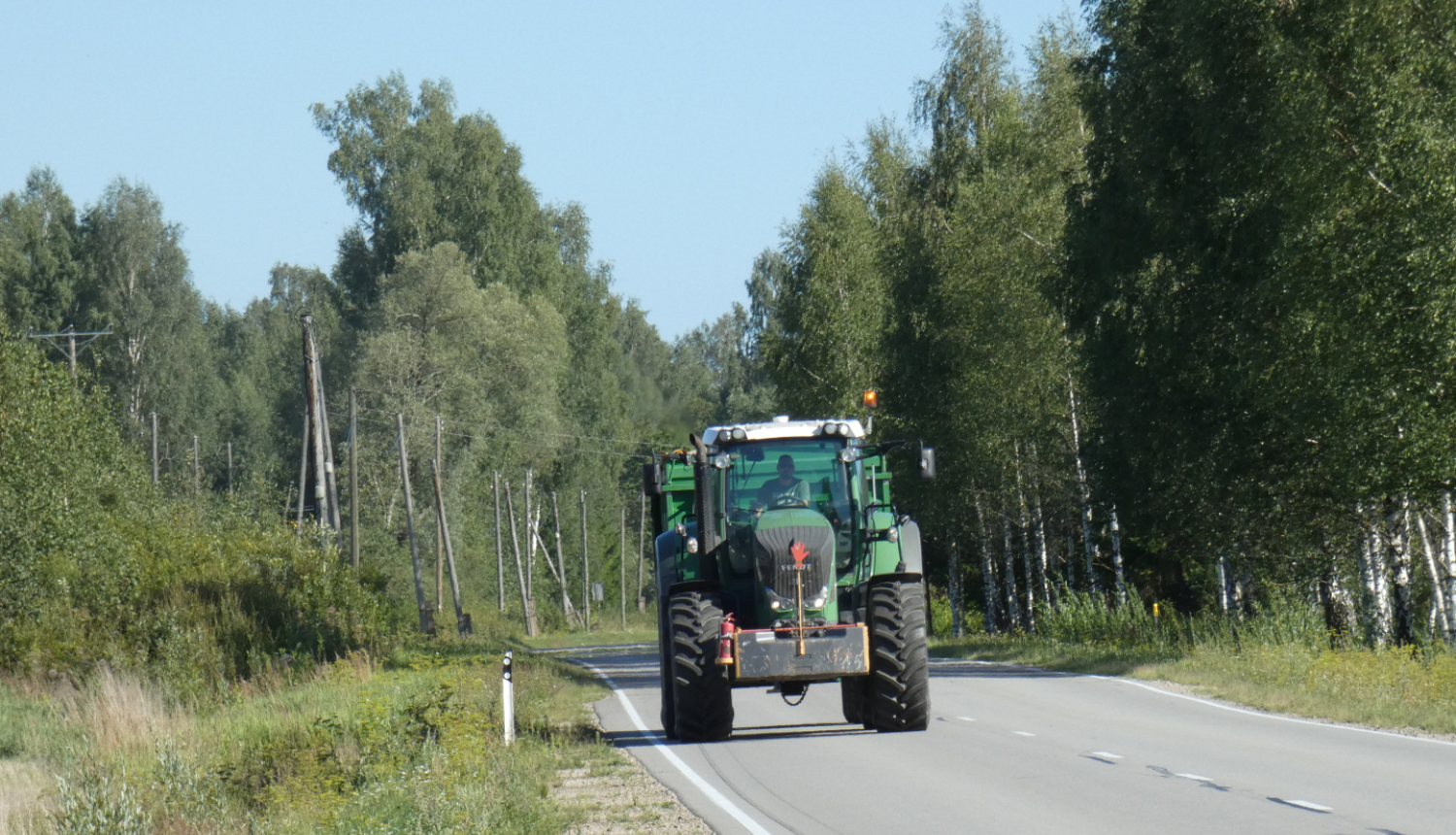 Braucošs traktors uz ceļa