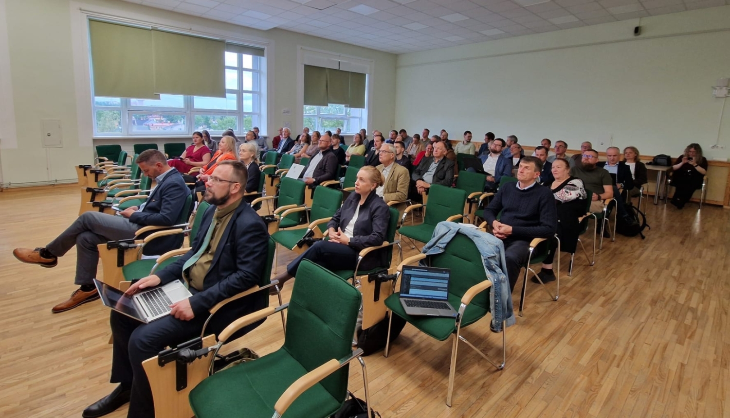 Atklāšanas pasākuma dalībnieki sēž zālē