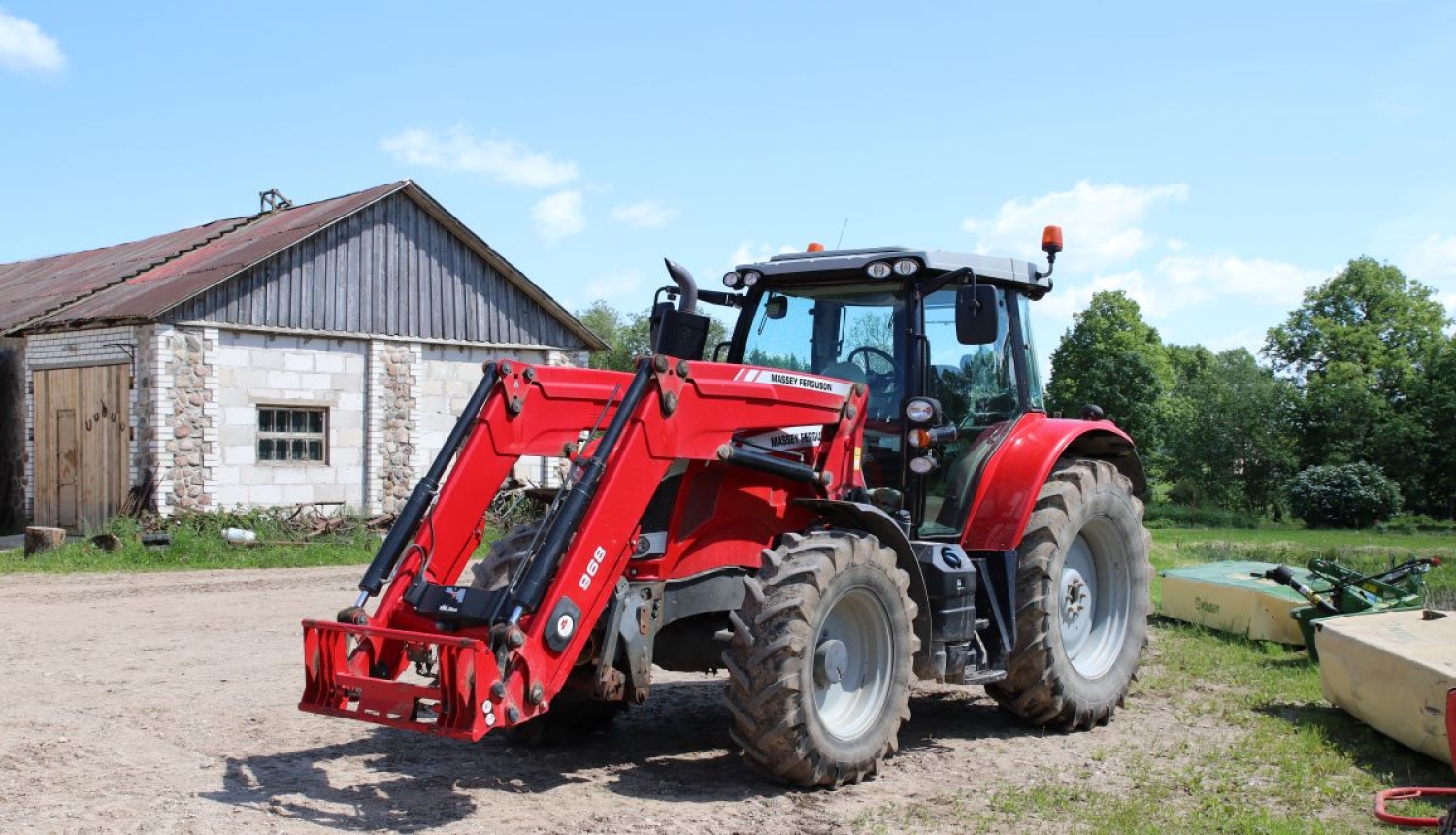 Sarkans traktors lauku sētā. 