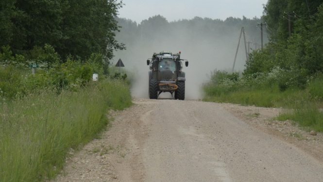 Braucošs traktors uz ceļa
