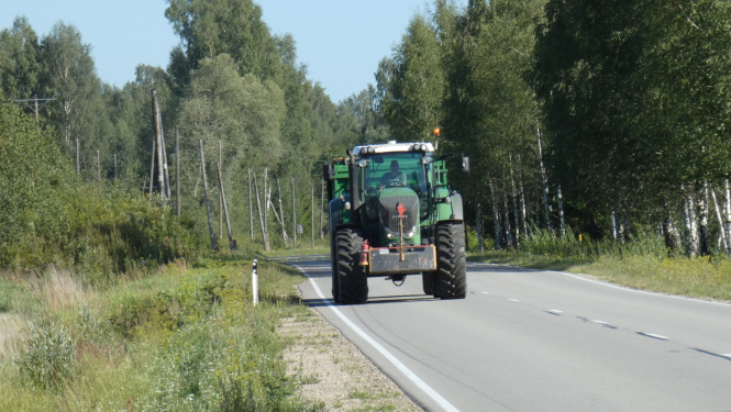 Braucošs traktors uz ceļa