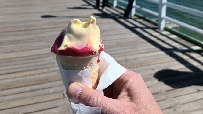 Uz koka laipas vīrietis rokās tur saldējumu