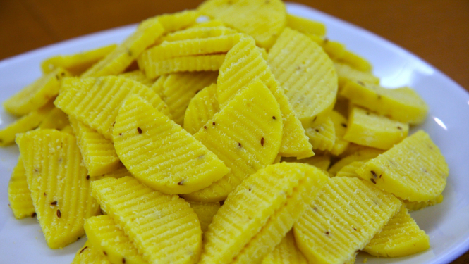 dzeltena ķimeņu siera šķēlītes uz šķīvja