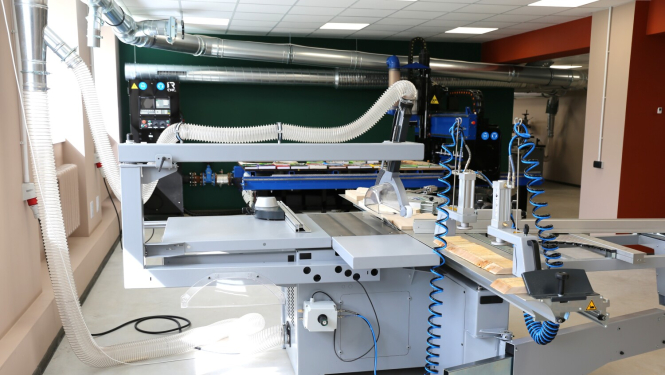 Attēlā redzama industriāla kokapstrādes iekārta.