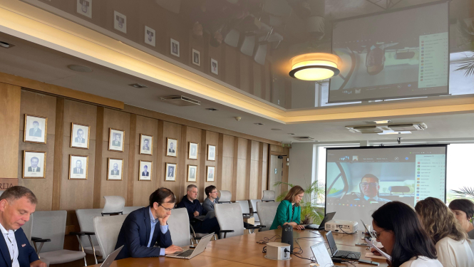 Sanāksme, cilvēki ar datoriem pie gara galda, 