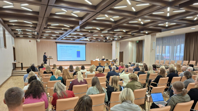 Cilvēki sanāksmē, liela zāle at ekrānu.