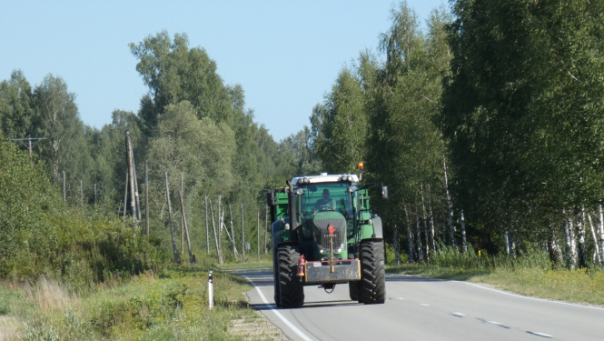 Braucošs traktors uz ceļa