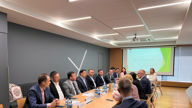 Delegācijas apspriež dokumentus, sēžot ap galdu