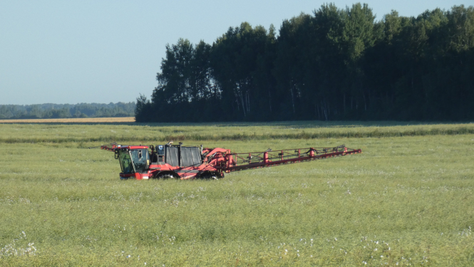 Mēslošanas līdzekļa smidzinātājs kultūraugu laukā 