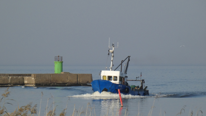 mazs zvejas kuģītis atgriežas Rojas ostā pēc zvejas piekrastē