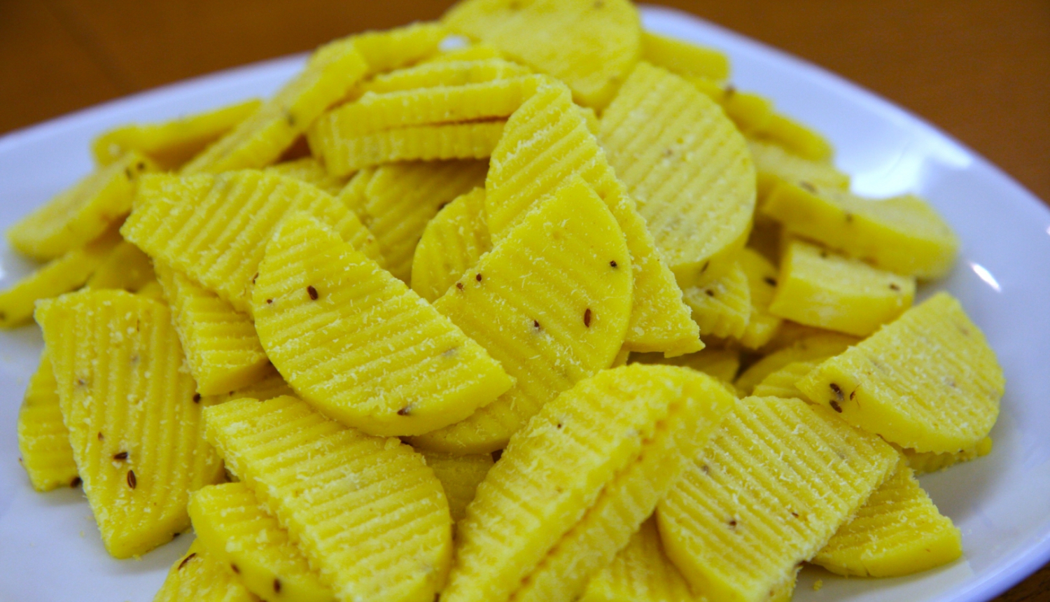 dzeltena ķimeņu siera šķēlītes uz šķīvja