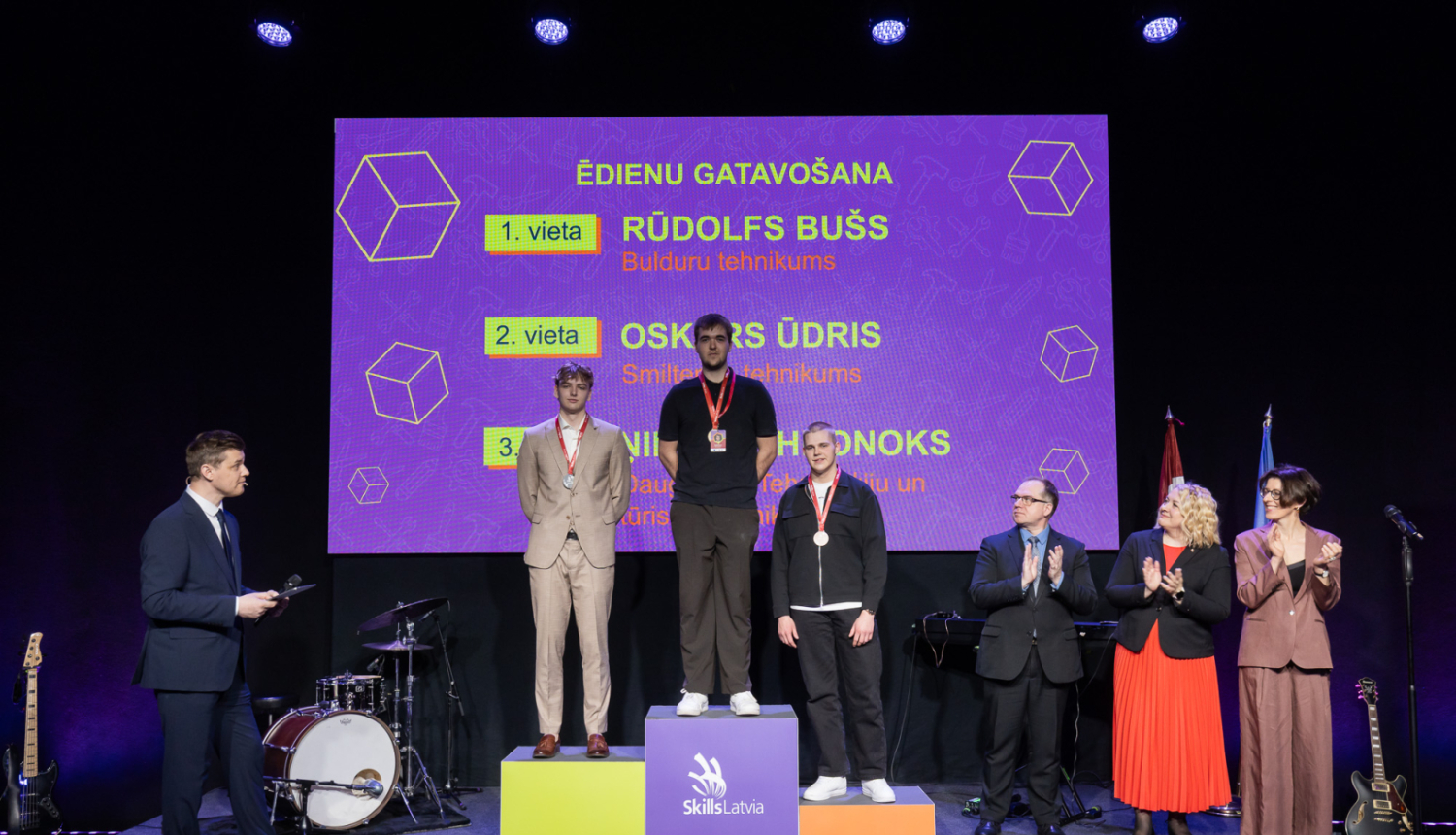 SkillsLatvia konkursa “Ēdienu gatavošana” laureāti apbalvošanas ceremonijā uz goda pjedestāla.