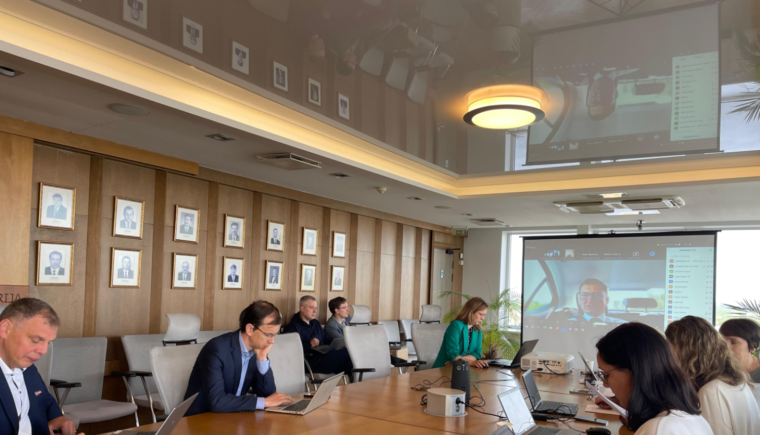 Sanāksme, cilvēki ar datoriem pie gara galda, 