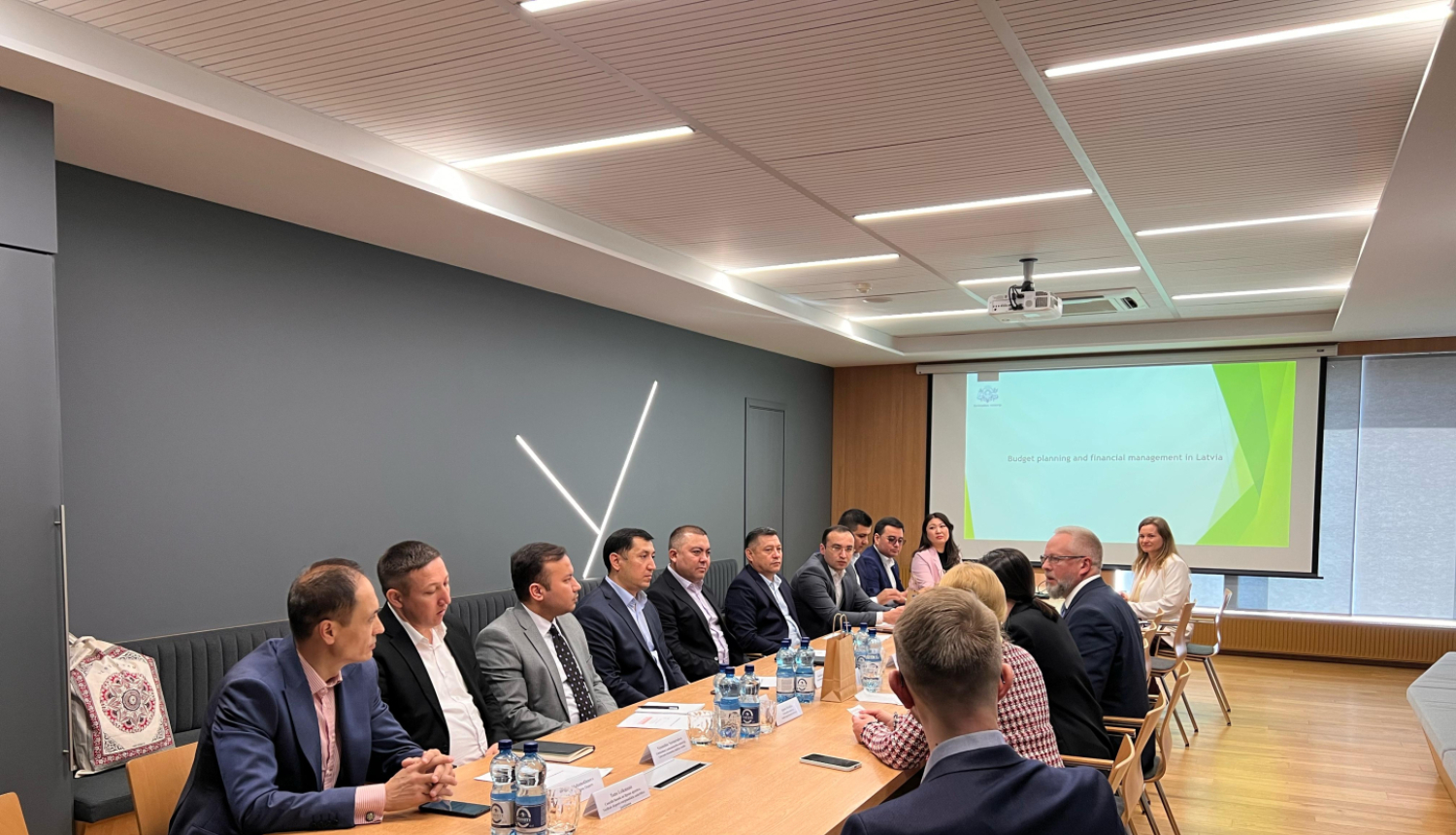 Delegācijas apspriež dokumentus, sēžot ap galdu