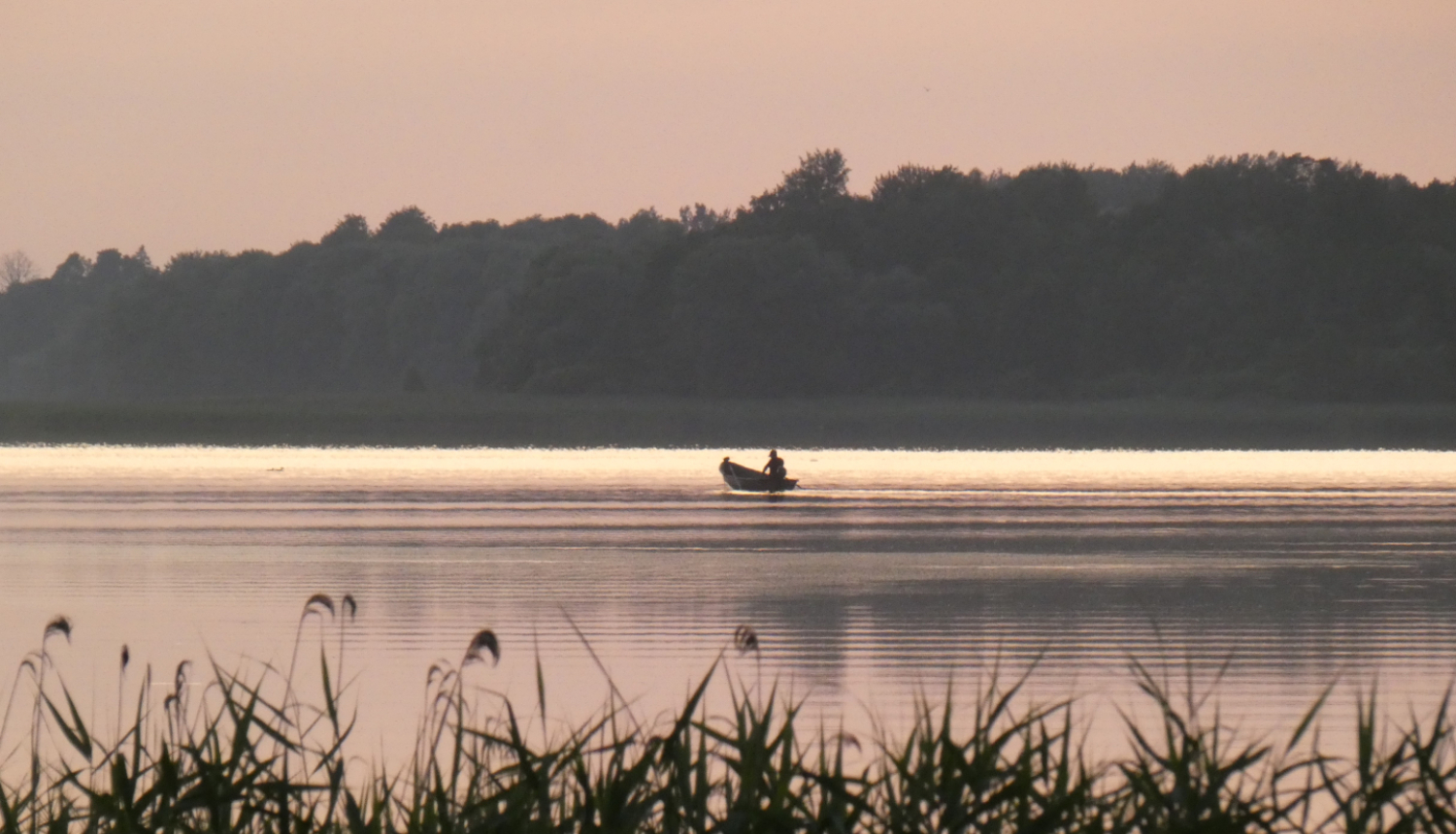 Laiva ezerā un makšķernieks 
