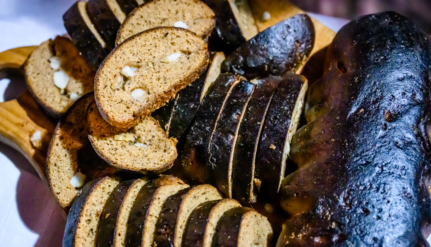 Rudzu maizes klaips, kurā ievīstīts žāvēts speķis un sīpoli