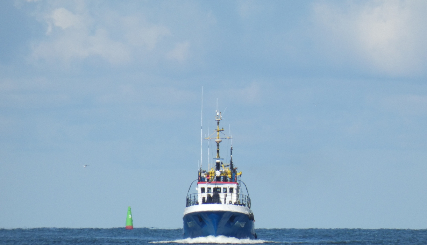 zvejas kuģis no jūras nāk uz ostas pusi