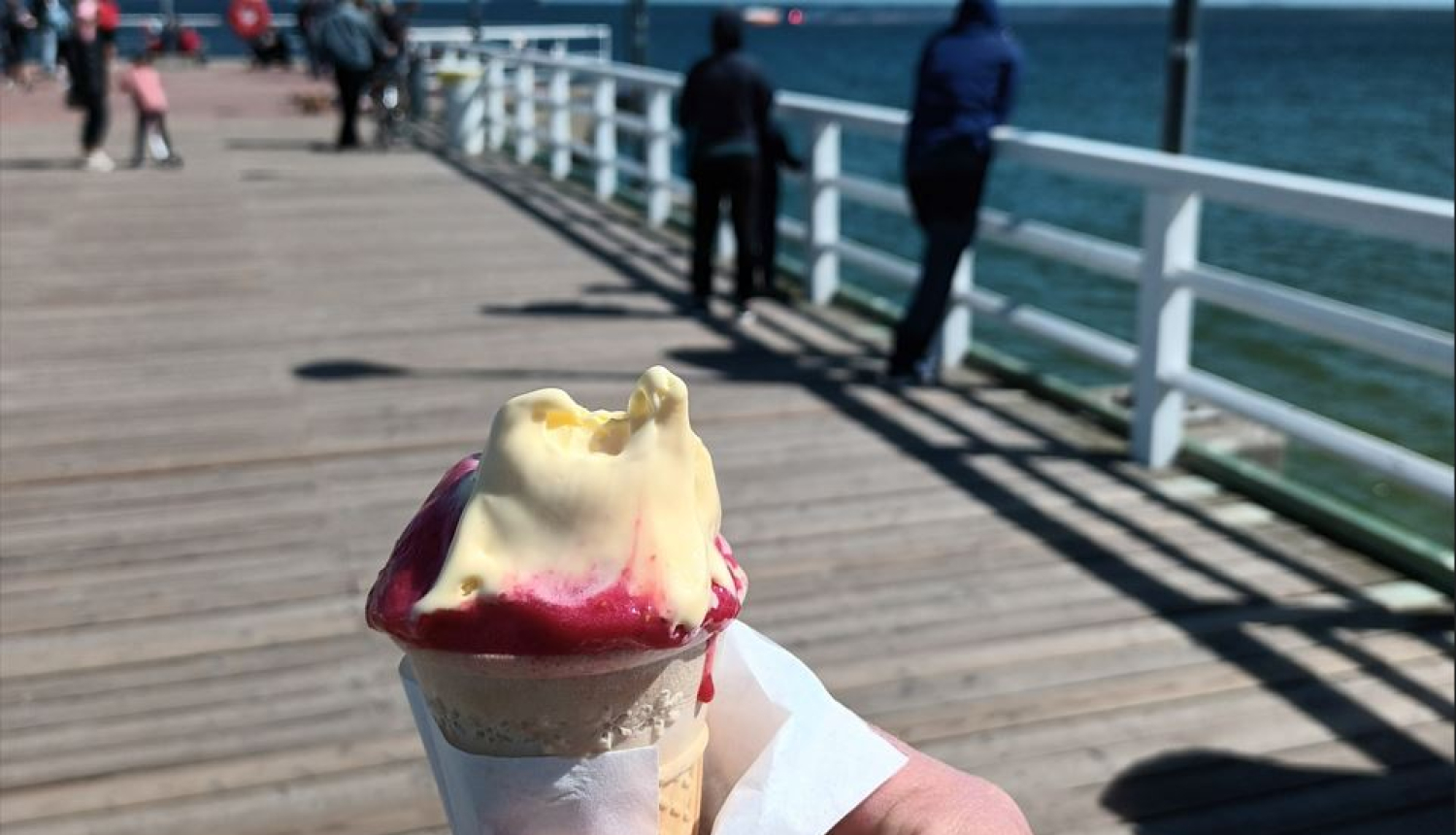 Uz koka laipas vīrietis rokās tur saldējumu