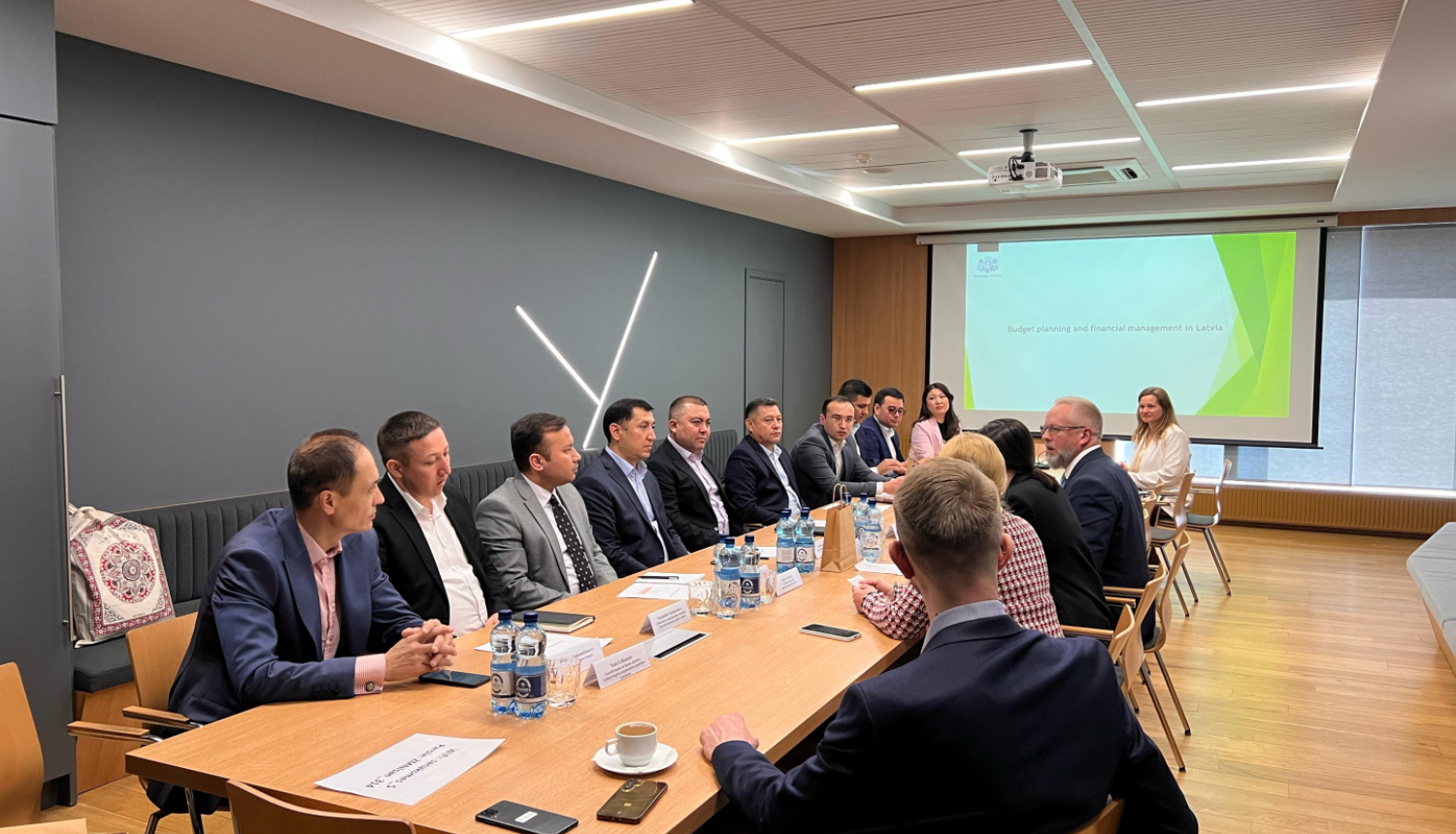 Delegācijas apspriež dokumentus, sēžot ap galdu