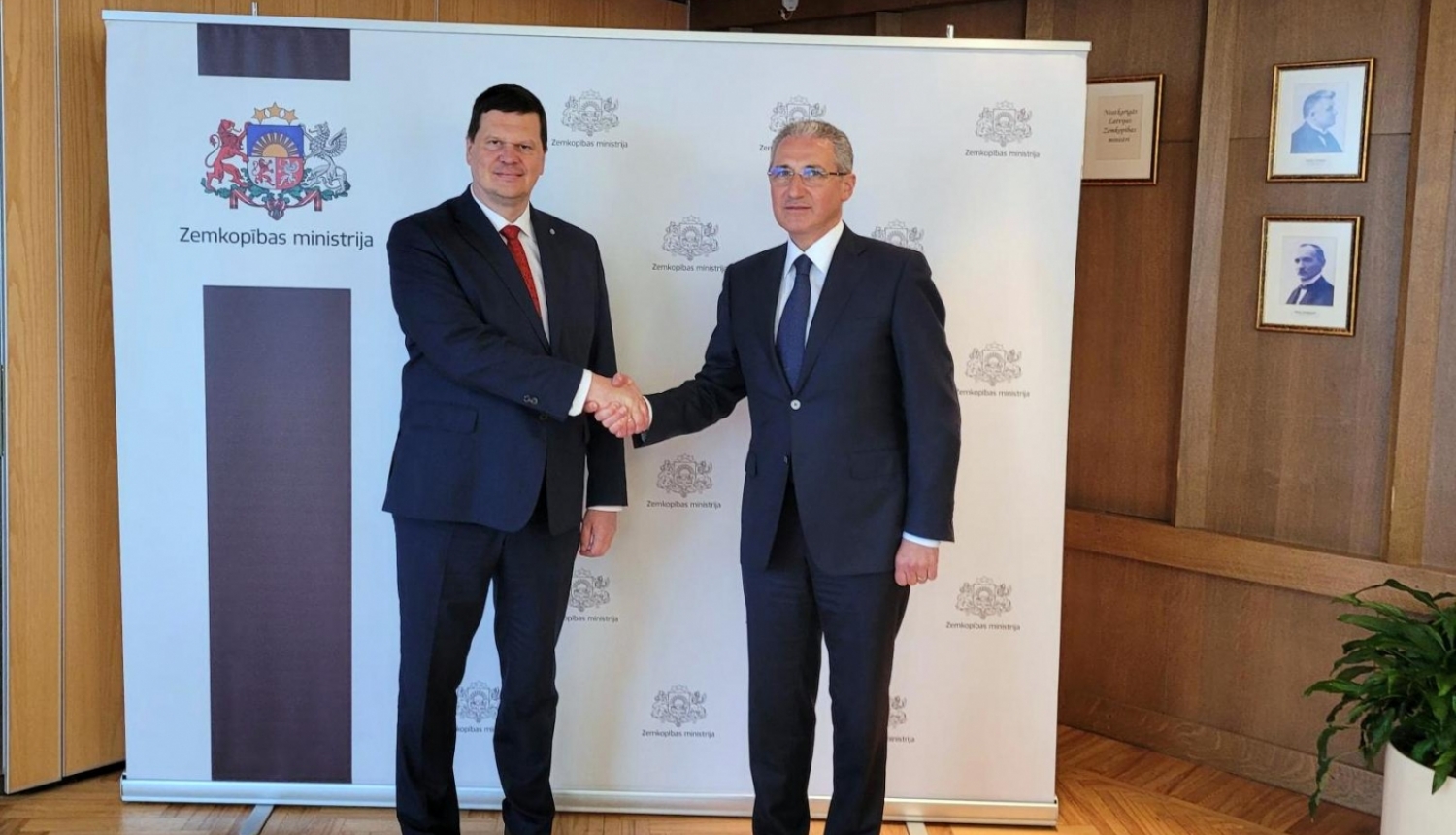 Divi vīrieši paspiež rokas